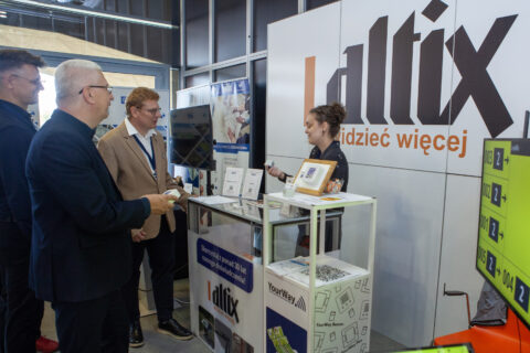 Zwiedzający rozmawiają z wystawcą przy stoisku firmy Altix z hasłem „widzieć więcej” podczas Accessibility Expo 2025.
