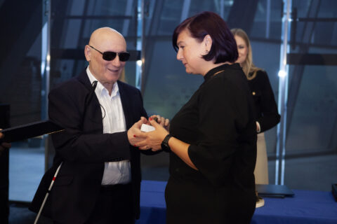 Laureat w ciemnych okularach i laureatka trzymają się za ręce, gratulując sobie na scenie gali IDOL 2025.